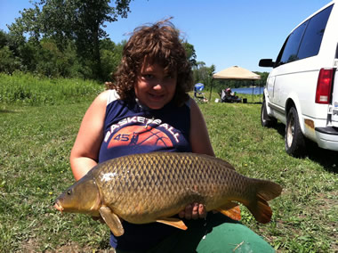 Nathaniel Knowles displays a 13 lb, 1 oz carp caught by his dad during the July 30 Shootout in Baldwinsville